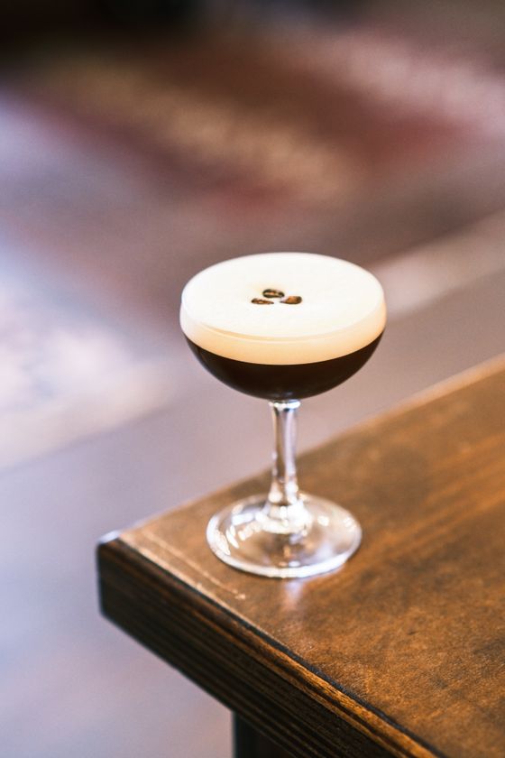 Espresso martini in a coupe with thick creamy foam and three coffee beans