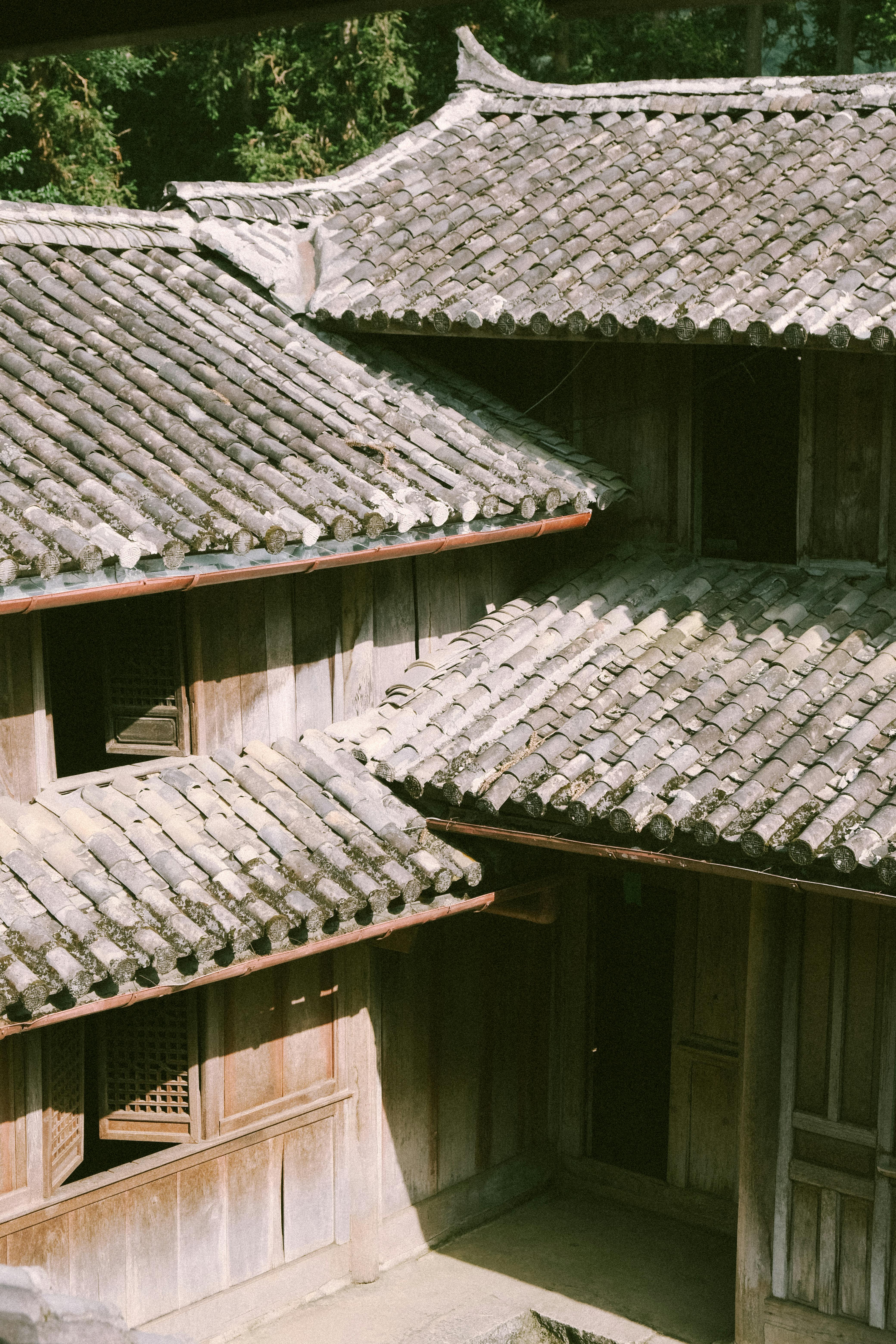 Free A traditional wooden building with tiled roofs sunlit, showcasing classic Asian architectural style. Stock Photo