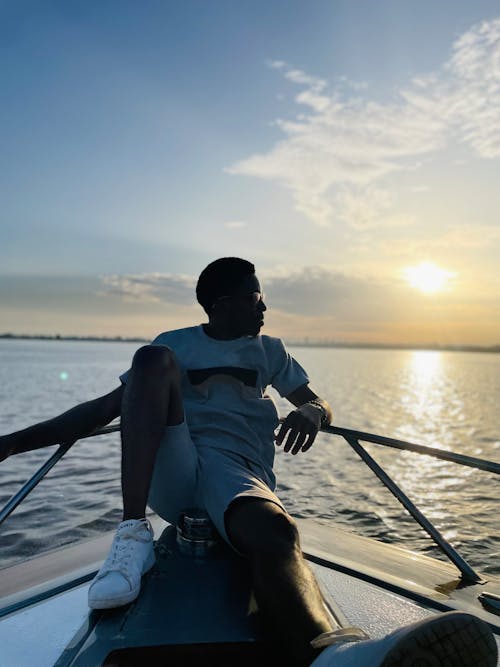 Man Sitting on Boat at Sunset