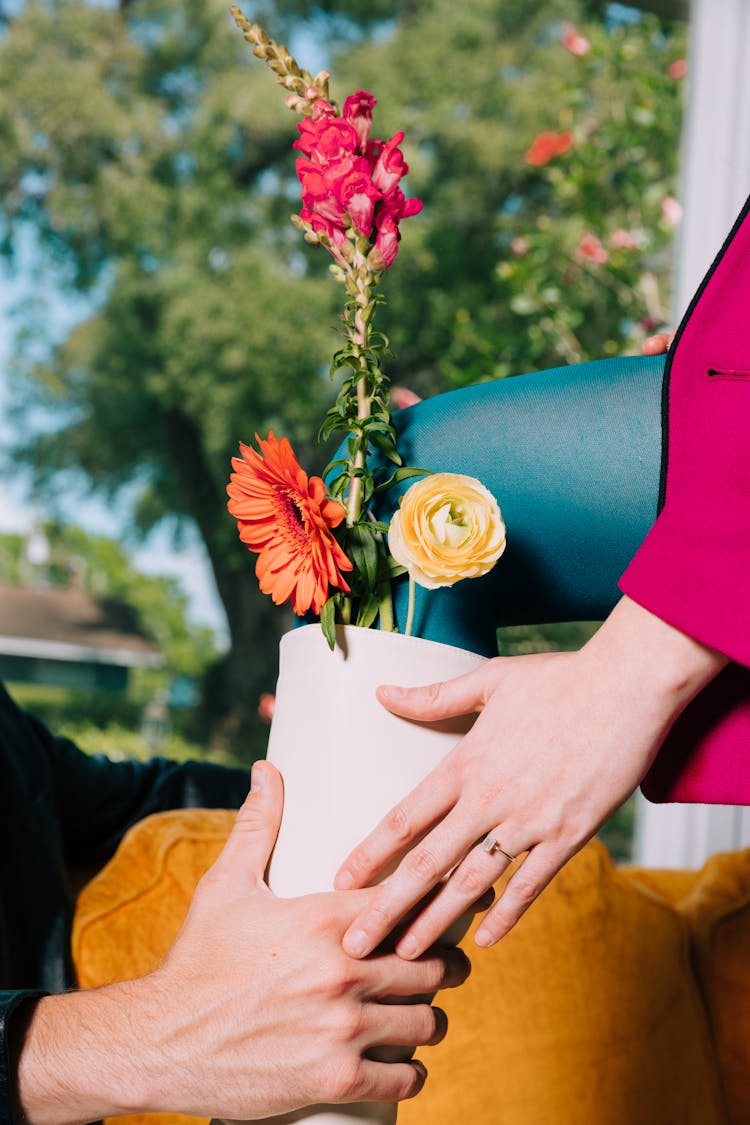 Woman Hand With Engagement Ring And Flowers 