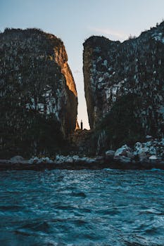 A stunning view of an ocean cliff formation at sunset, creating a natural passage.