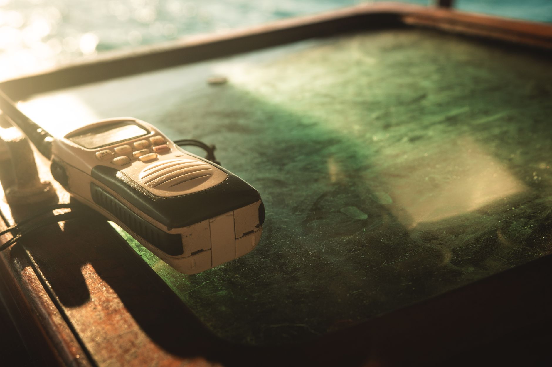 A vintage walkie talkie placed on a sunlit table, conveying communication and nostalgia.