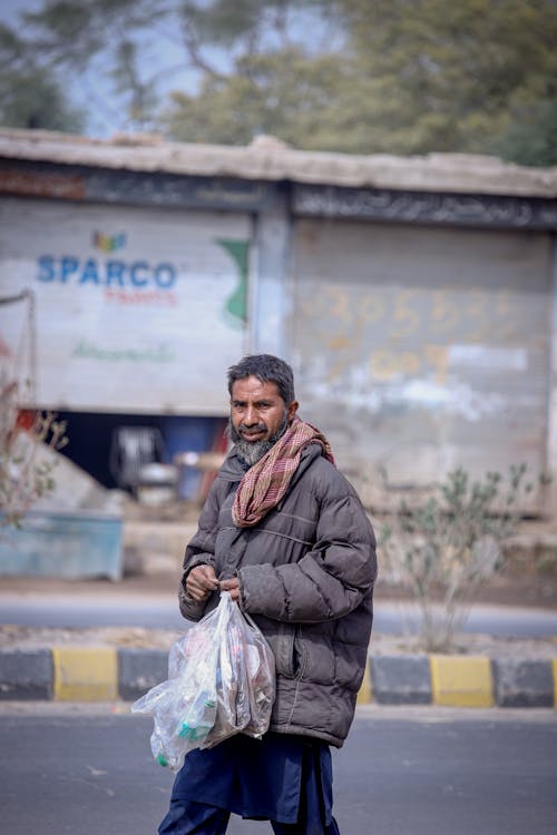 Homeless Man with Bag Walking on Street