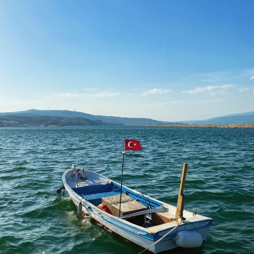 Free A traditional boat with a Turkish flag sails on scenic blue waters under a clear sky. Stock Photo