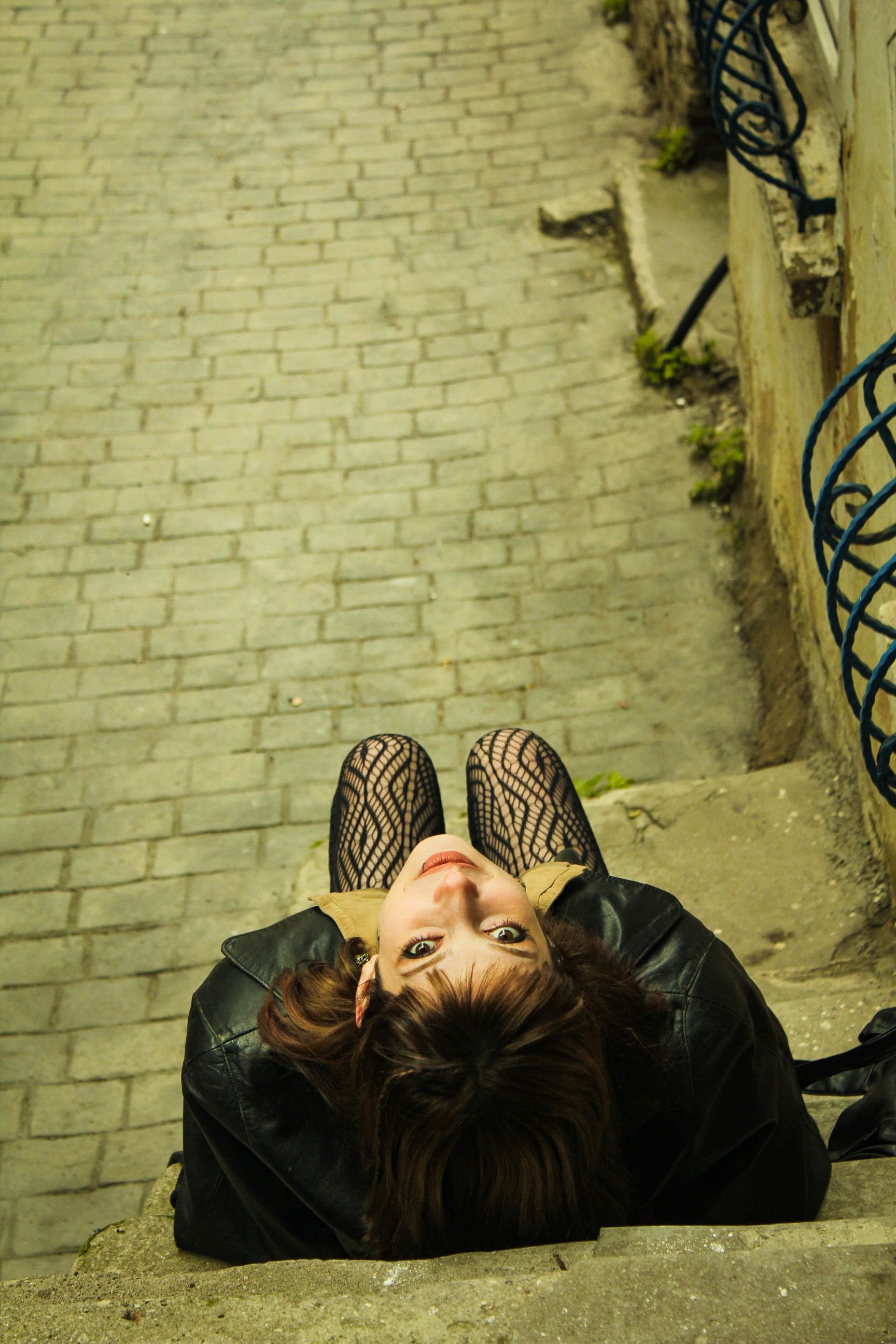 Fotomural Captivadora toma aérea de una mujer en escaleras de piedra, creando un ambiente artístico e introspectivo.