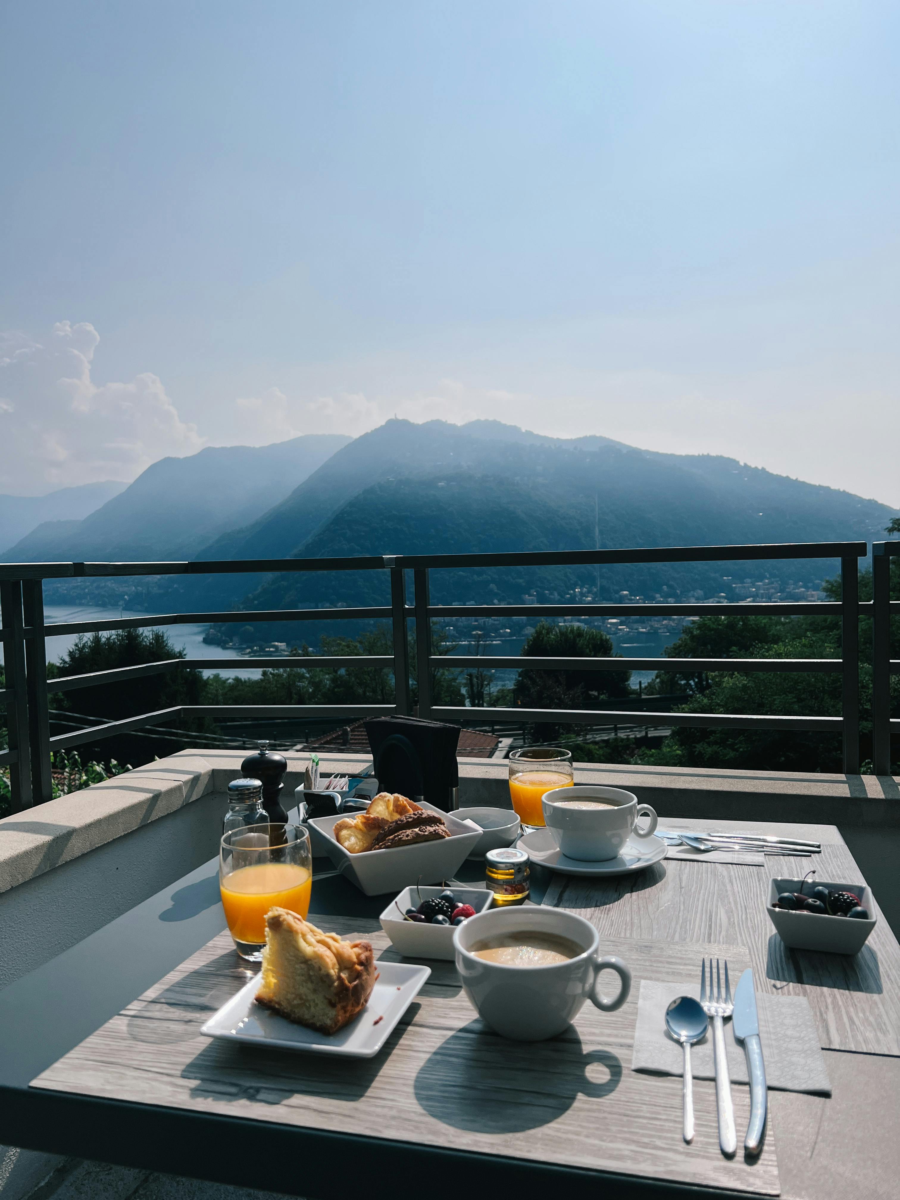 Enjoy a delicious breakfast with a breathtaking mountain view from a serene terrace setting.