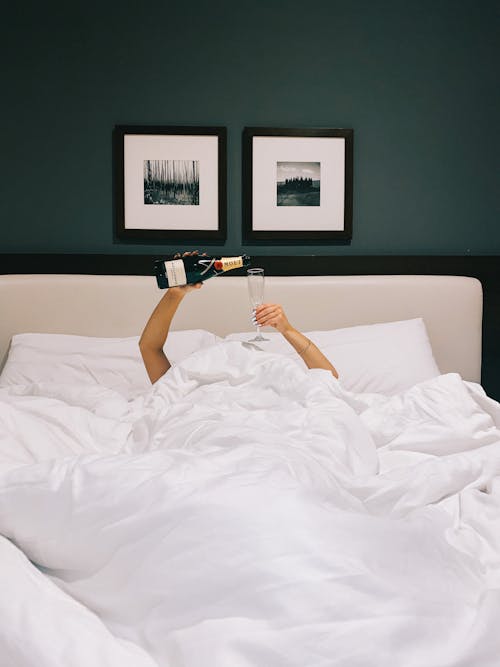 Free Woman Pouring Champagne in a Bed Stock Photo