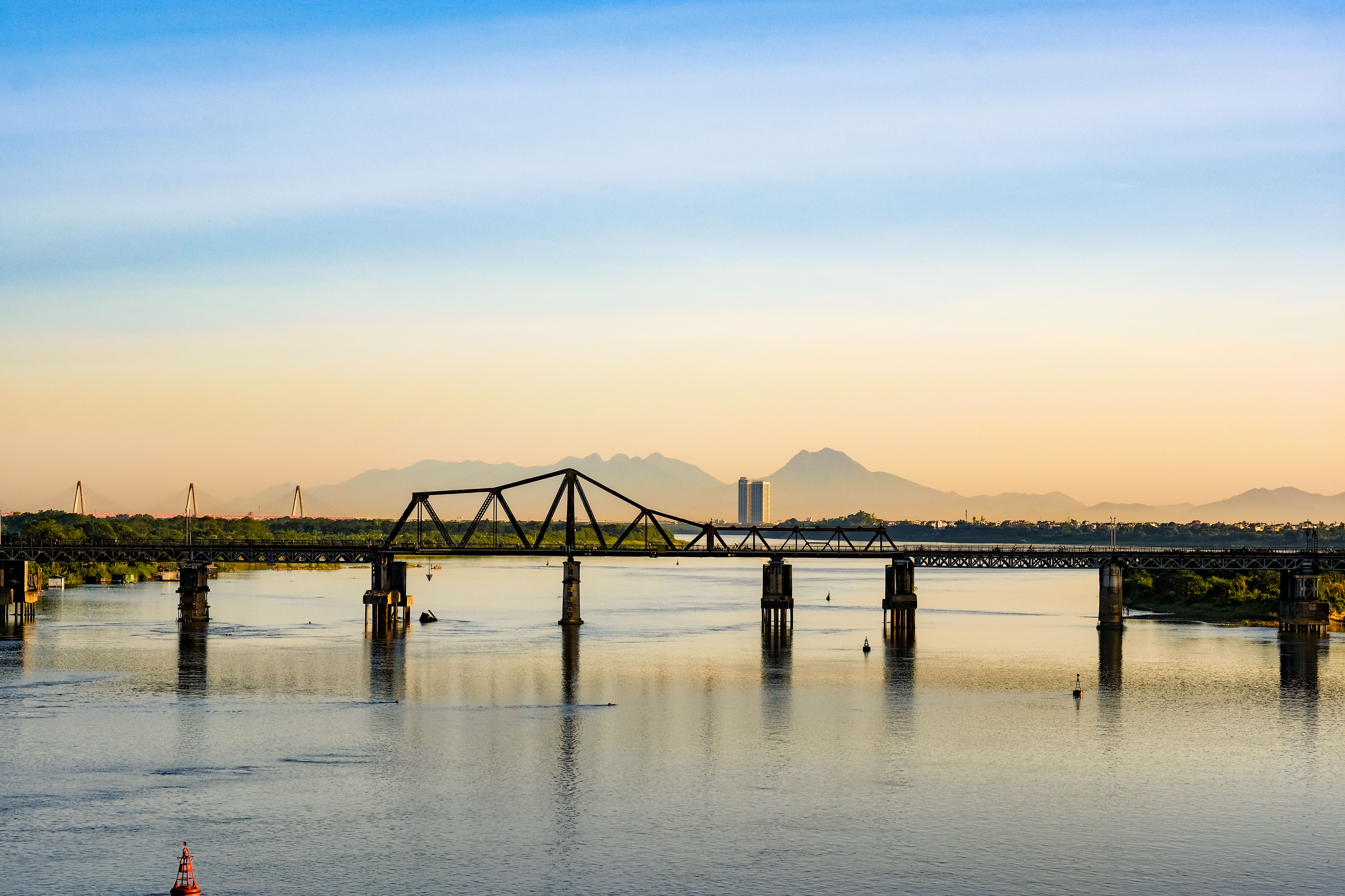The Bridge over the River Kwai in Kanchanaburi with train crossing at dusk