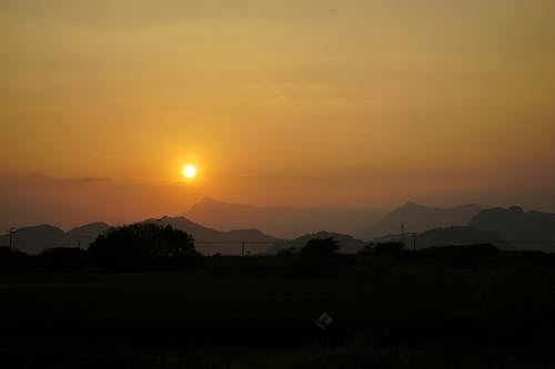 Foto profissional grátis de cair da noite, céu dourado, colinas