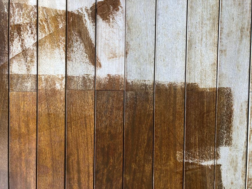 Close-up of a rustic wooden fence with peeling white and brown paint, highlighting texture.