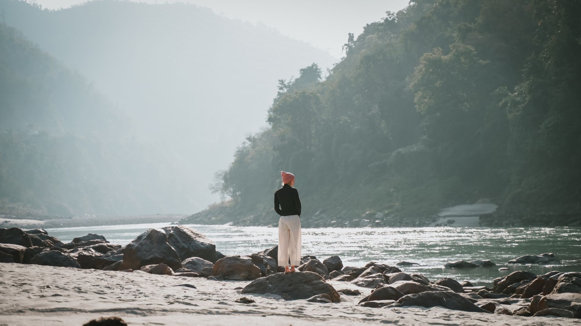 Woman standing by the Ganges river in Rishikesh