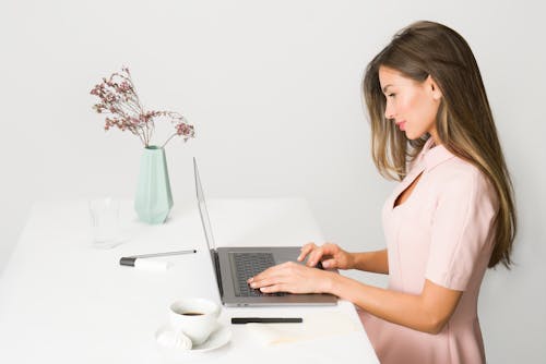 Gratis Mujer En Vestido Rosa Con Ordenador Portátil Foto de stock