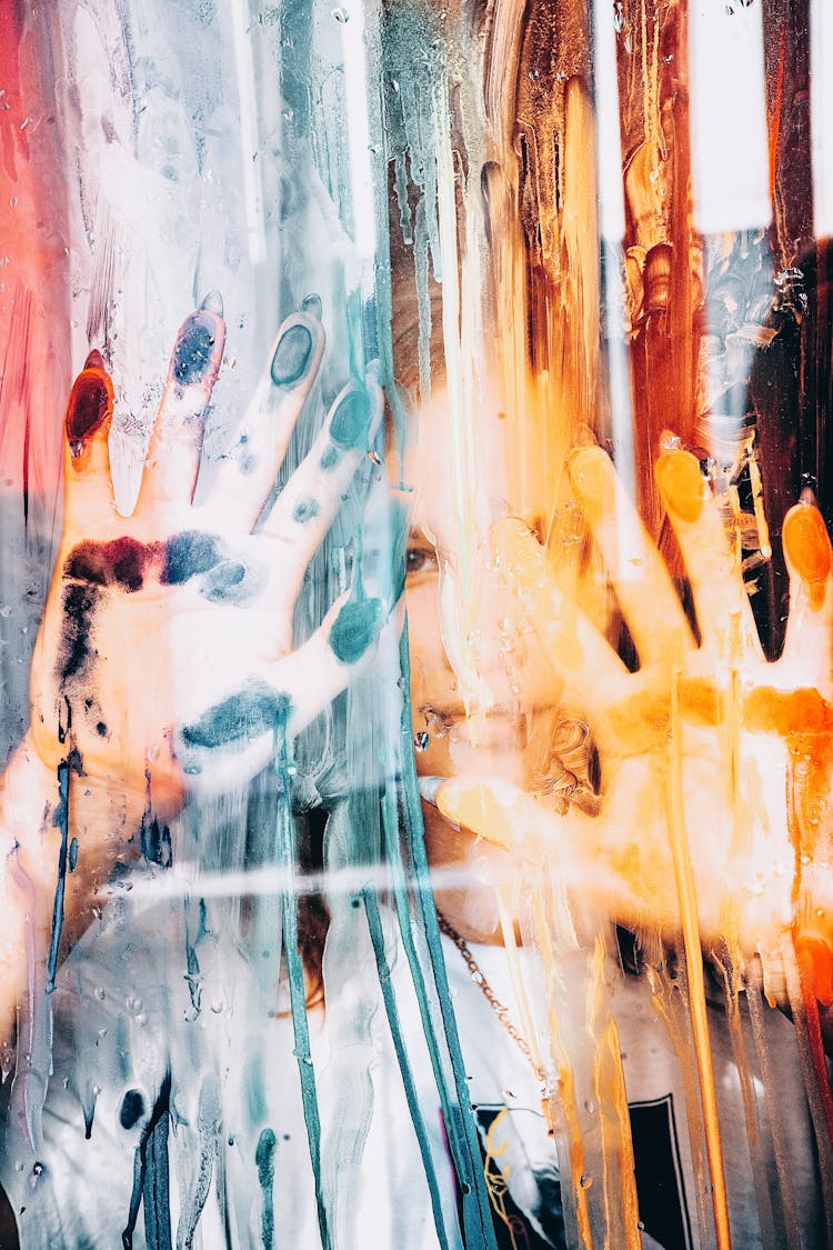 Girl Pressing Hands To Paint Covered Glass