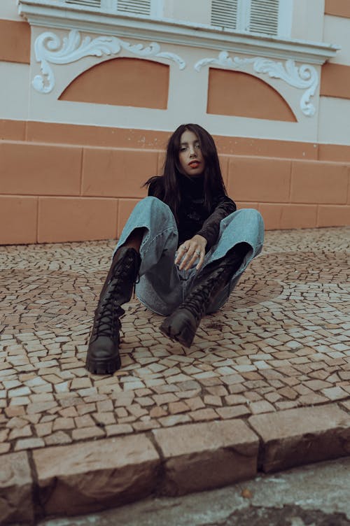 Woman Wearing Combat Boots Sitting on Sidewalk