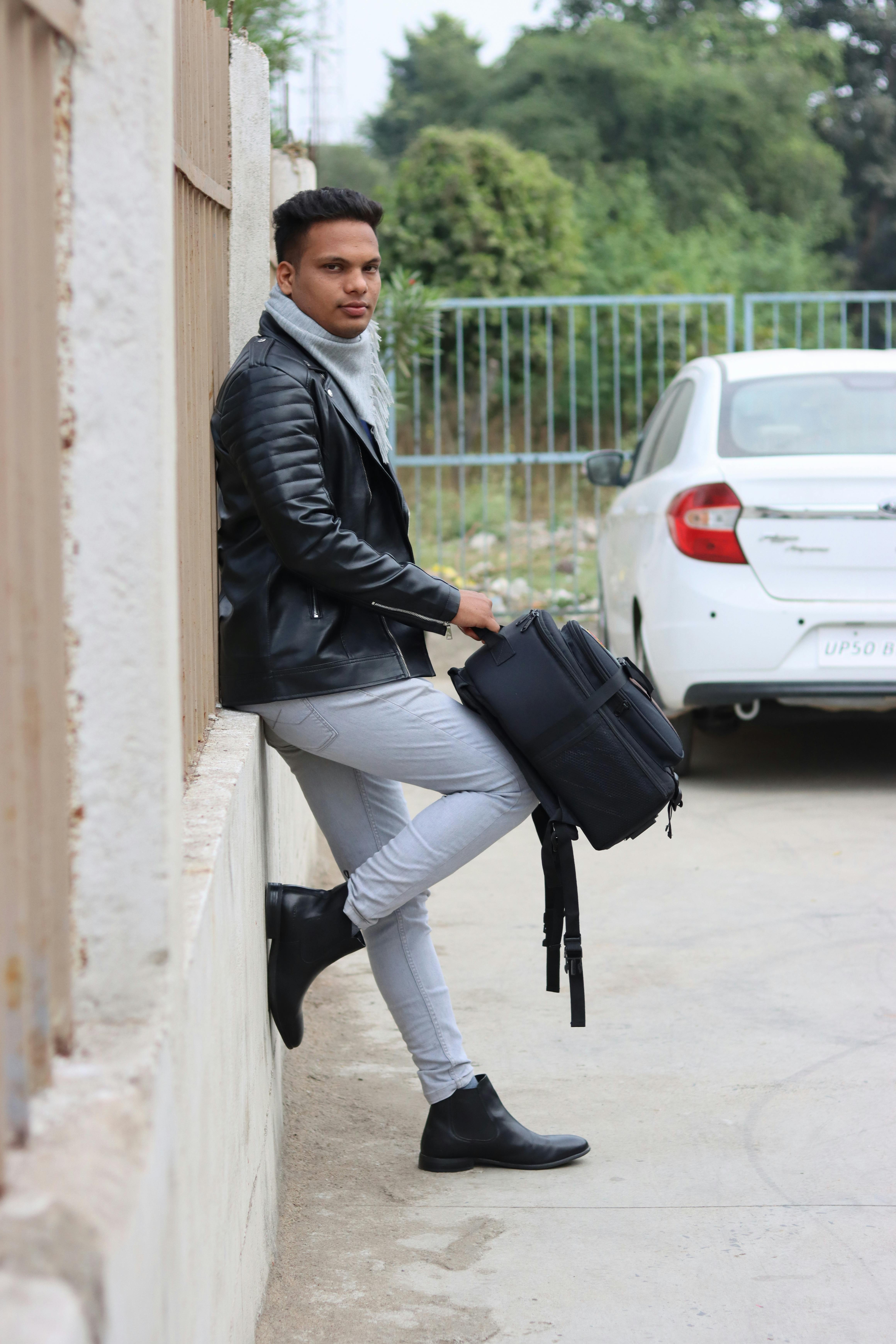 Man in Leather Jacket Leaning Against Fence · Free Stock Photo