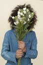 Person Holding White Flower Bouquet Covering Face