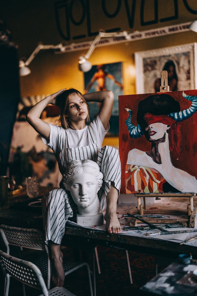 Girl Posing In Artists Studio With A Painting And Sculpture