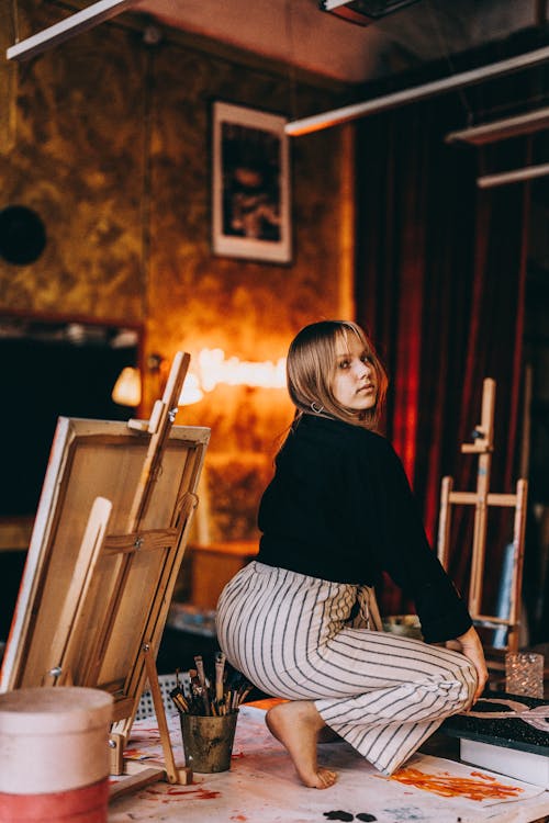 Woman Crouching in Painting Workshop