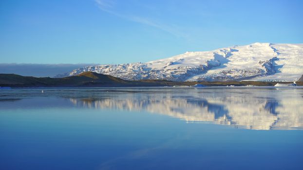 Placid Sea Reflected Snowed Mountain