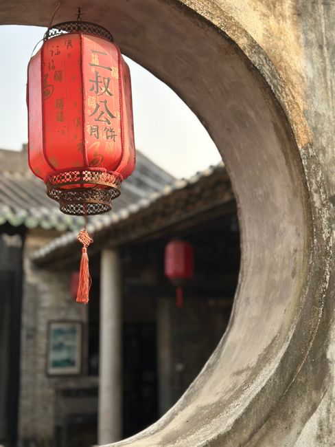 Close-up of a red lantern hanging in a traditional Asian architectural setting, highlighting cultural heritage.