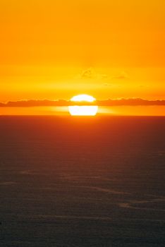Stunning sunrise with golden hues illuminating the sea horizon, creating a serene and dramatic atmosphere.