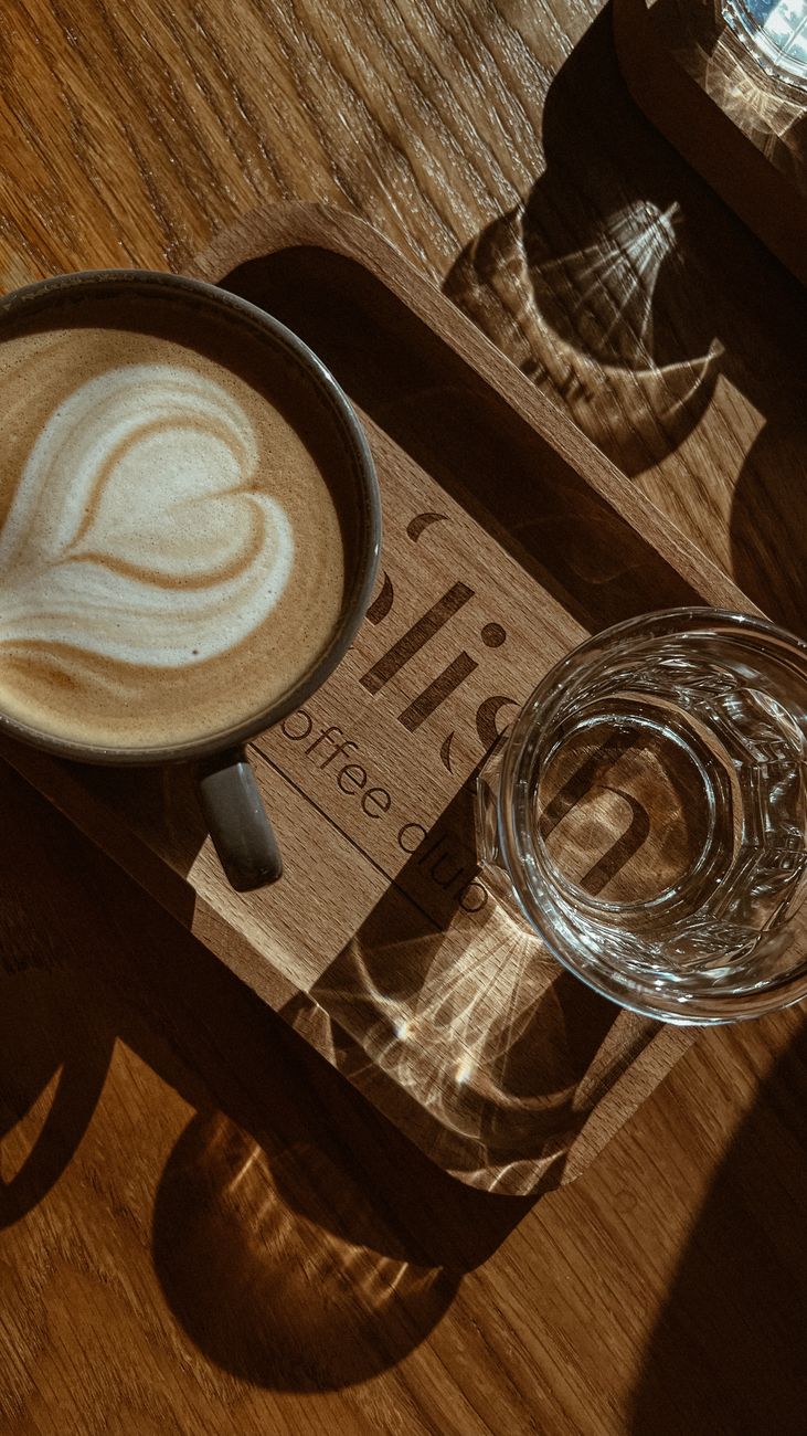 A captivating photo of a cappuccino with heart latte art, bathed in warm morning sunlight.