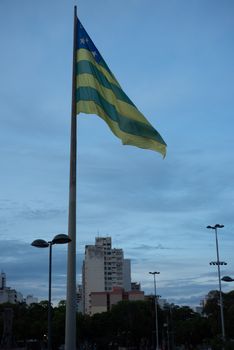 City flag waving against a twilight sky with an urban backdrop, creating a serene atmosphere.