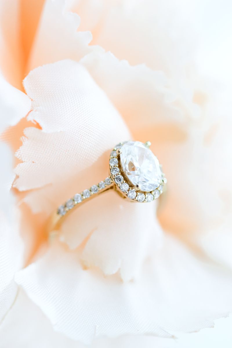 Luxury diamond ring displayed on delicate peach-hued petals