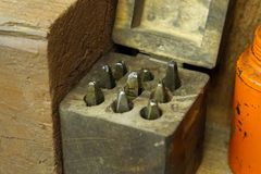 Rustic workshop scene with an open vintage wooden box containing metal tools on a wooden bench.