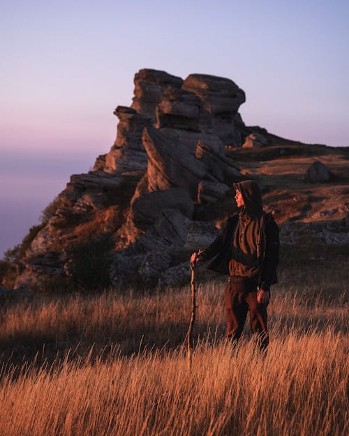 Man Standing in the Meadow and Looking at a View 