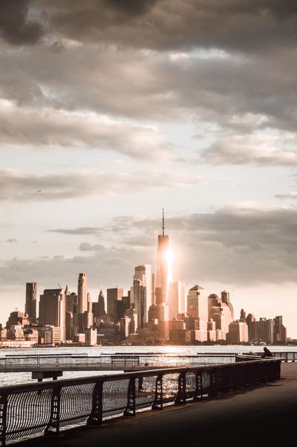 A breathtaking view of the New York City skyline at sunset with dramatic clouds.