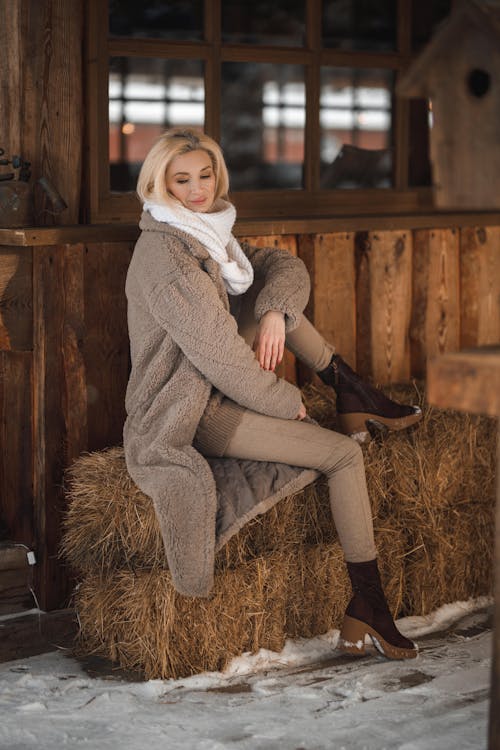 https://images.pexels.com/photos/15872755/pexels-photo-15872755/free-photo-of-young-woman-in-warm-clothing-sitting-on-a-hay-bale-in-a-barn.jpeg?auto=compress&cs=tinysrgb&dpr=1&w=500
