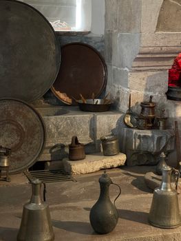 Collection of vintage metal and iron kitchenware in a historic Konya, Türkiye setting.