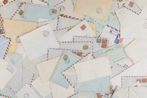 Close-up of Scattered Envelopes with Postage Signs 