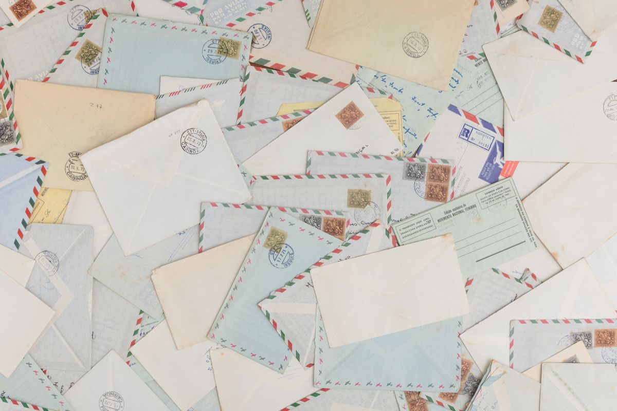 Cartoline e buste da viaggio con francobolli appoggiate su un tavolo