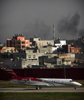 An ambulance plane ready for takeoff against a backdrop of dense urban architecture.