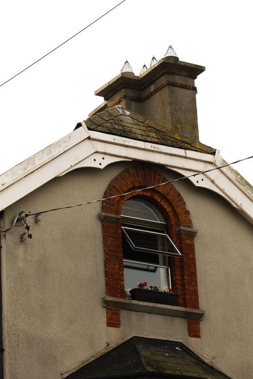 Free Close-up of a classic house facade with open window and flowers, showcasing timeless architectural design. Stock Photo