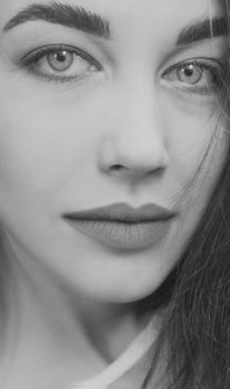 Sophisticated close-up black and white portrait of a young woman with striking features.