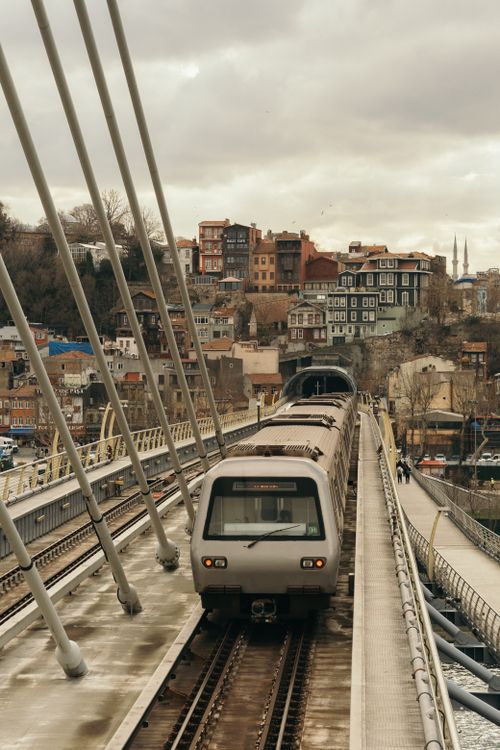 Free A train travels over a modern bridge with a scenic urban backdrop. Stock Photo