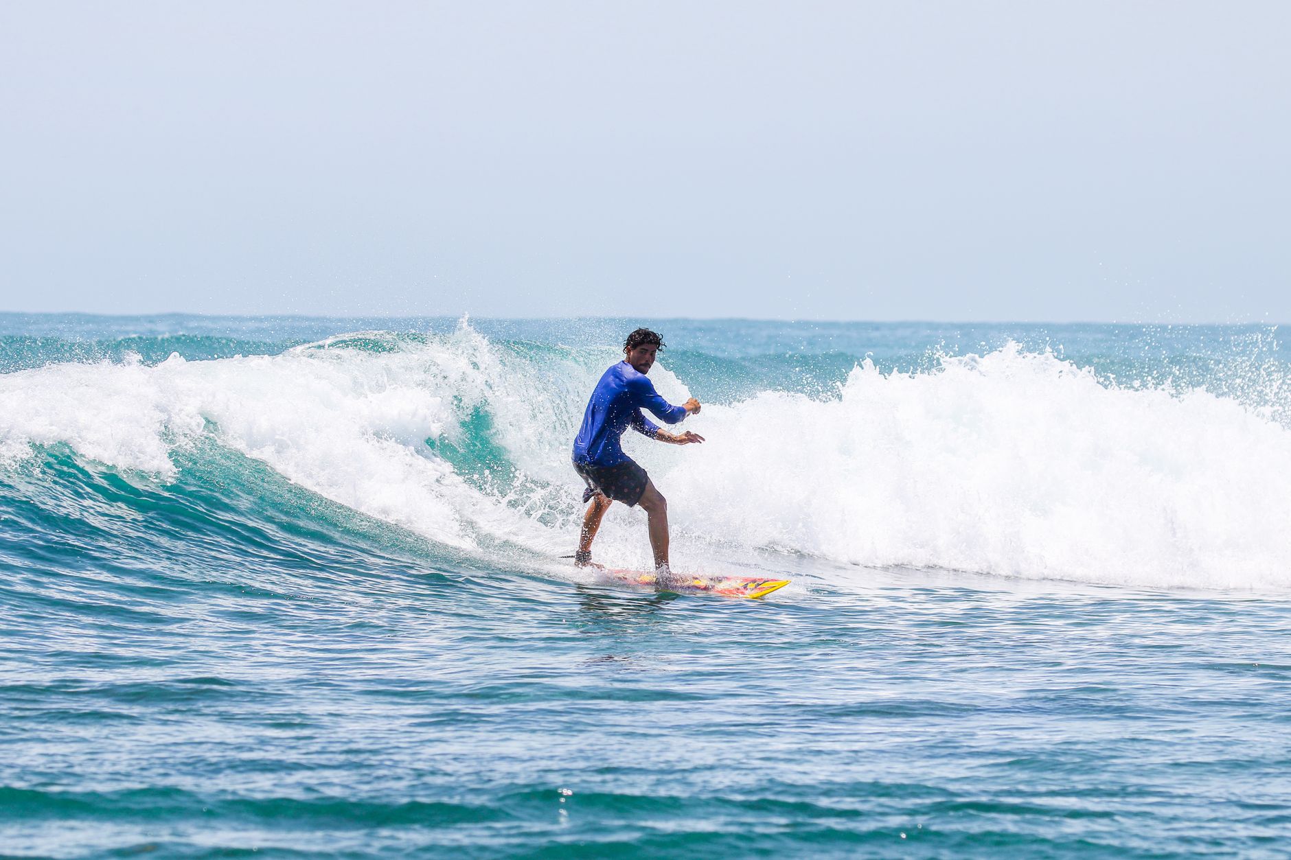 A skilled surfer catching a wave on a sunny day, showcasing balance and adventure.