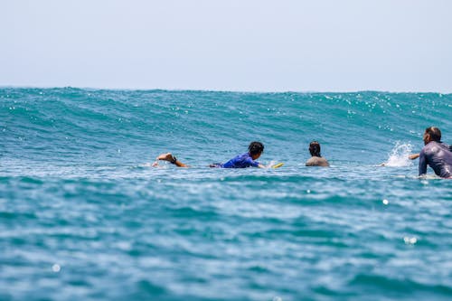 Men Lying on Surfboards on the Sea Surface 