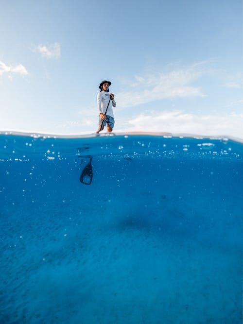 Picture Taken Half Underwater of a Man on a Paddle Board