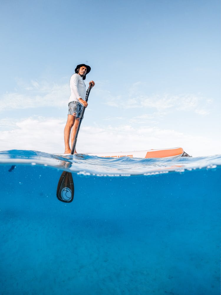 Picture Taken Half Underwater Of A Man On A Paddle Board