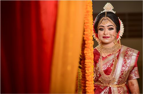 Free A smiling Indian bride in ornate traditional attire with jewelry and embroidery for a cultural wedding. Stock Photo