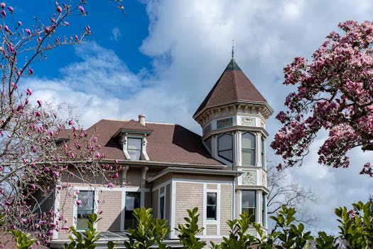 Charming Victorian house with spring blossoms and blue sky.