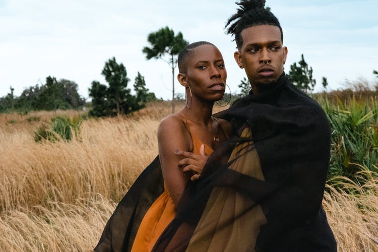 Elegant Man And Woman Posing Together On A Field 