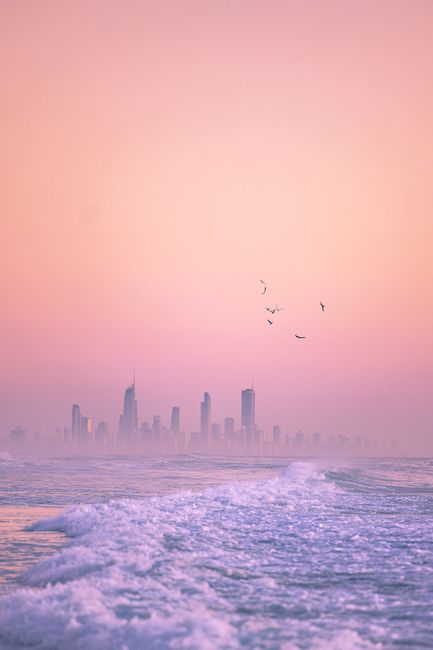 Mesmerizing view of Currumbin skyline with pink twilight and ocean waves.
