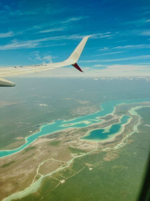 Stunning aerial photo of Bacalar Lagoon from an airplane, showcasing vibrant water colors.