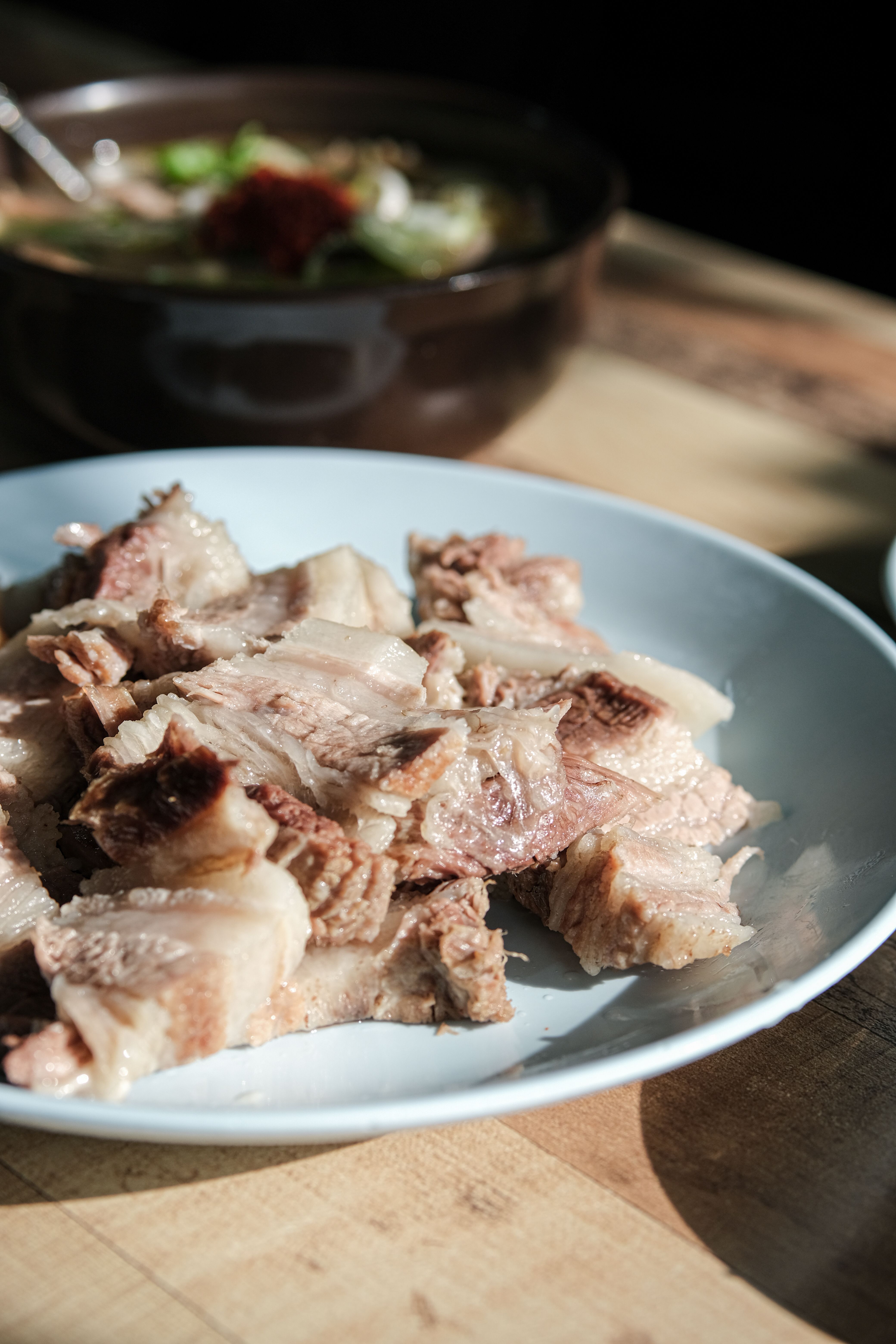 Close-up shot of delicious cooked beef slices on a plate in natural sunlight, perfect for foodies.