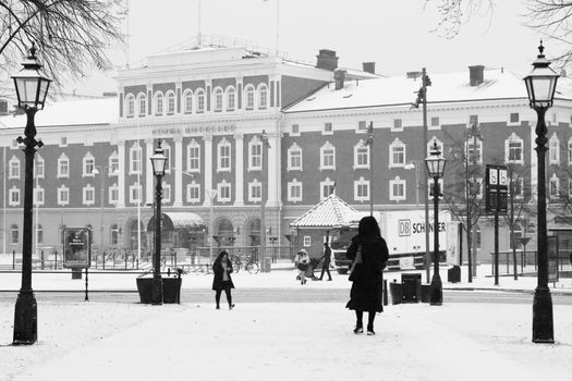 Black and white winter scene capturing people in Jönköping's city center, Sweden.
